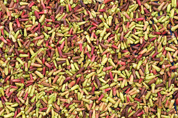 Green and red cloves for sale in market stock photo