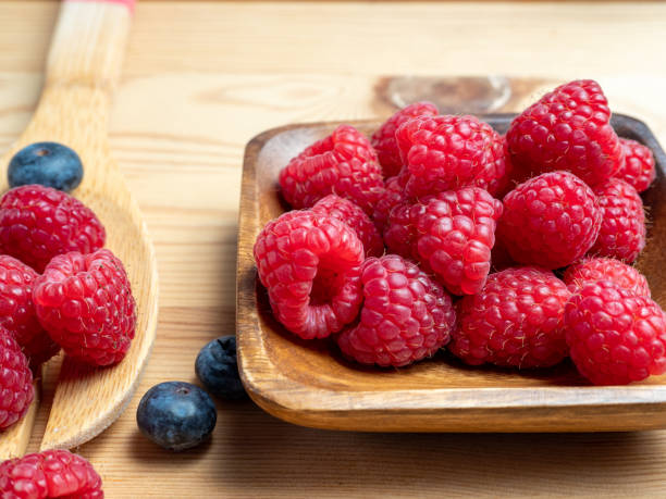 istock Raspberries in a wooden bowl 1369781673