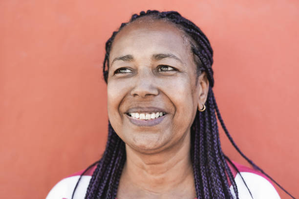 istock African senior woman smiling with red background 1369781895