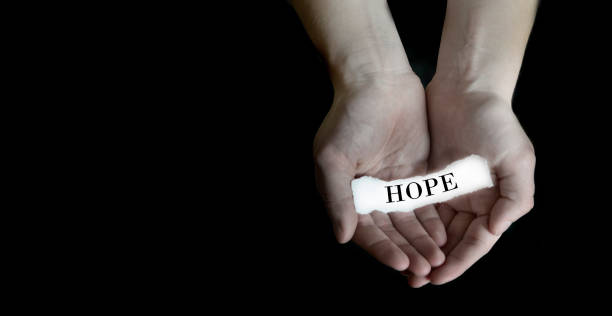 istock Hands Holding Paper Message hope on Black Background 1369782491