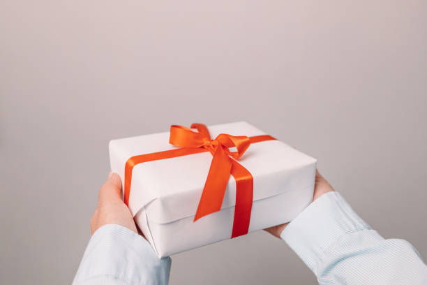 istock Gift in female hands on a gray background. Banner, copy space. 1369782809