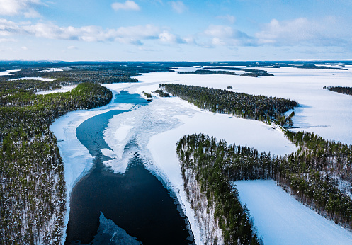 Aerial view of snow winter river with green forest