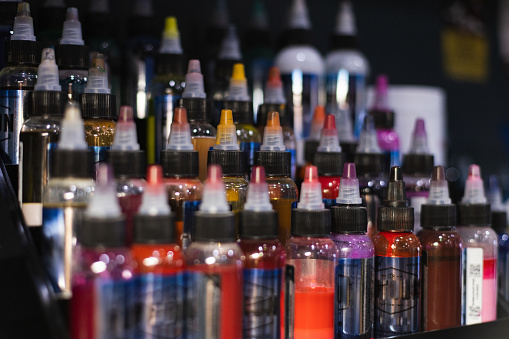 Palette of multicoloured tattoo inks. Tattoo salon. Selective focus, blurred