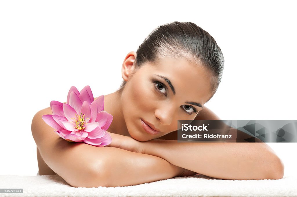 Beautiful woman enjoying a spa day with a lotus flower Young beautiful woman relaxing with lotus flower at spa isolated on white background, professional beauty makeup. Beautiful Woman Stock Photo