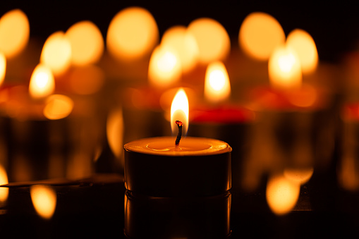 candle,Many candles burn with a shallow depth of field,Burning candles in darkness