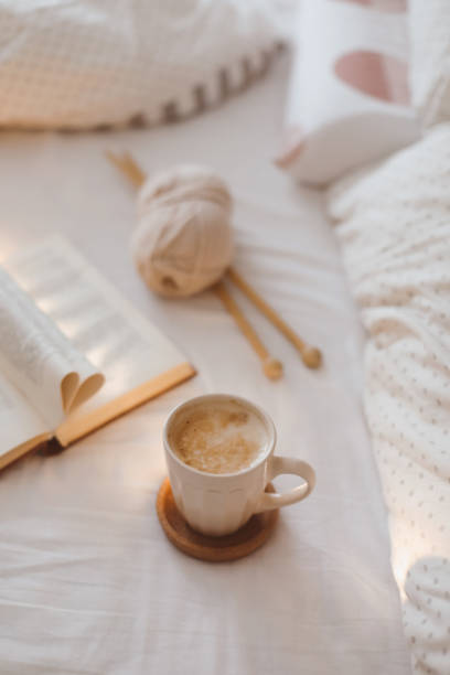 istock Cozy morning still life with a coffee cup, needles and a book with pages folded into a heart shape in bed 1369788548