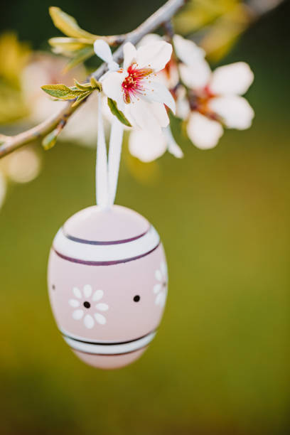 istock Beige boho Easter egg hanging on an almond branch 1369789295