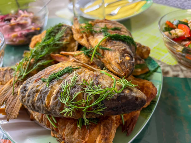 istock Sliced and fried fish with herbs on the plate. 1369789314