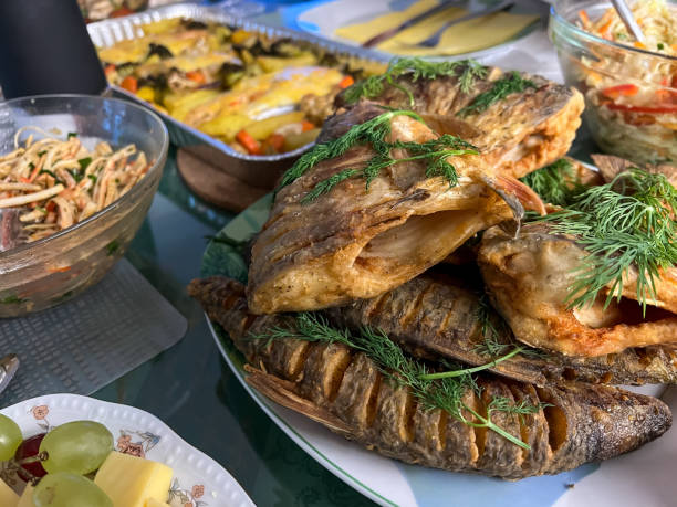 istock Delicious Christmas dinner with fish, vegetables, fruit and bread. 1369789445