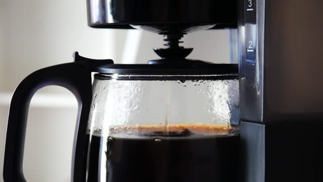A beautiful drip coffee maker brewing coffee close-up