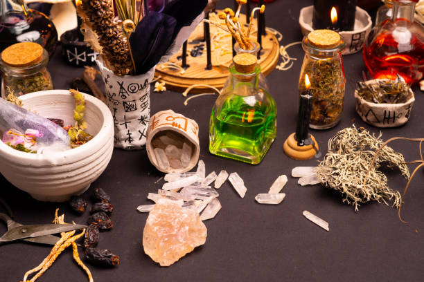 Witchcraft still life with black burning candles selective focus. Esoteric gothic and occult witch ritual for Halloween. Various magic objects and ceremony arrangement. Gothic Halloween.
