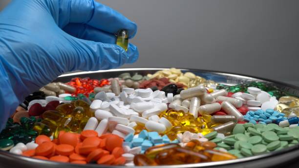 istock Scientists developing drugs. Quality control research in medical science laboratory. Medical worker hands in blue gloves holding the pill capsule for clinical trial. 1369795761