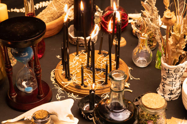 istock Witchcraft still life with black burning candles selective focus. Esoteric gothic and occult witch ritual for Halloween. Various magic objects and ceremony arrangement. Gothic Halloween. 1369795882