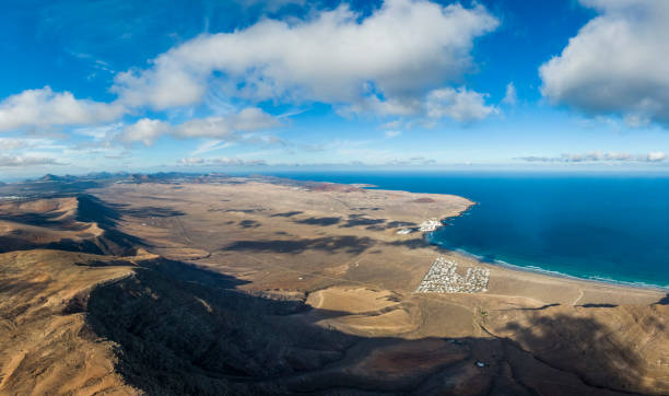 Aerial view of El Jable desert and and Famara village, Spain Aerial view of El Jable desert and and Famara village, Lanzarote, Spain caleta de famara lanzarote stock pictures, royalty-free photos & images