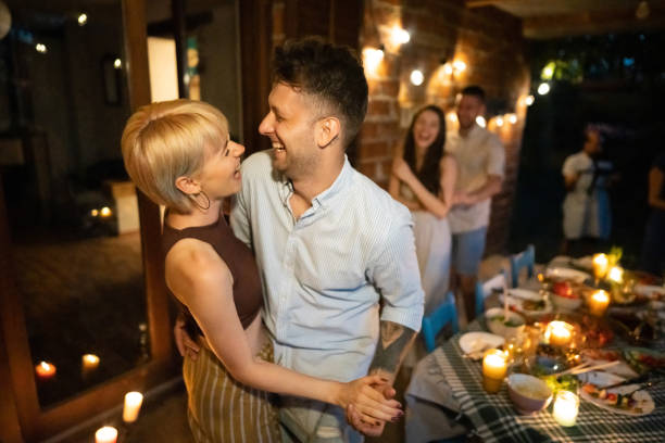istock Romantic couple, dancing during dinner party with their friends 1369800639