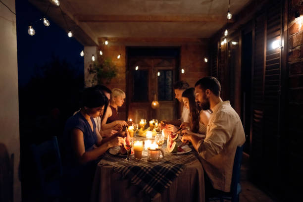 istock During summer night, carefree friends enjoy romantic dinner 1369801026