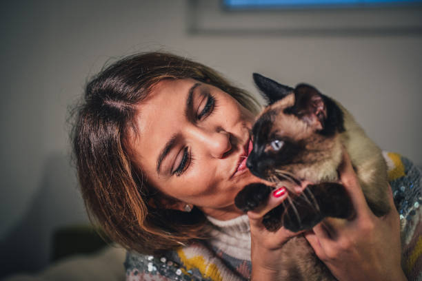 istock Young woman with her Siamese cat 1369803434