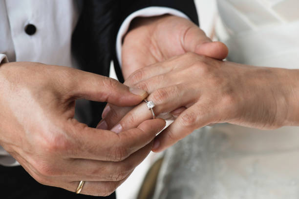 istock Midsection Of Couple Exchanging Wedding Ring 1369803998
