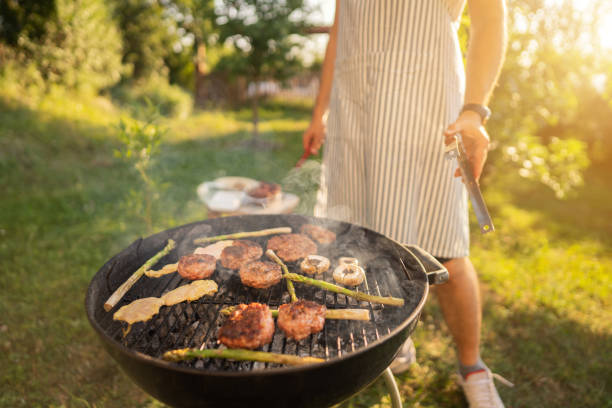 istock Unrecognizable men preparing the beef burger and chicken breast on the BBQ grill 1369805183