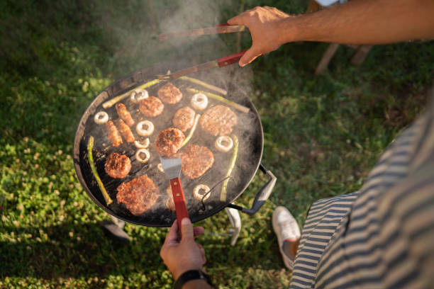 istock Unrecognizable men preparing the beef burger and chicken breast on the BBQ grill 1369805186