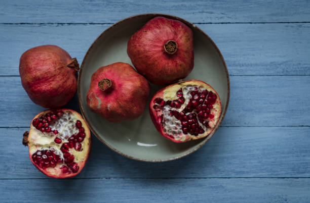 istock Ripe pomegranate fruit on wooden background 1369806291