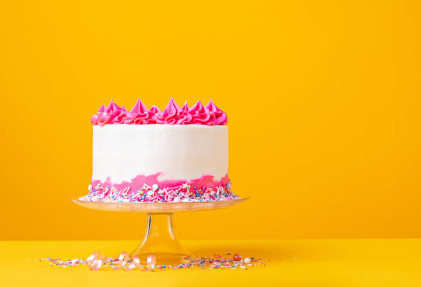 istock Pink and white Birthday Cake on a Yellow Background 1369812755