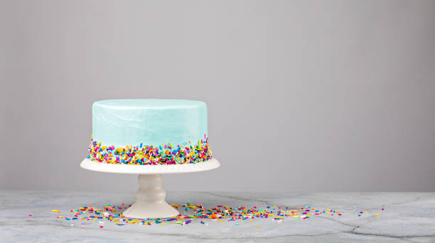 istock Blue Cake with colorful sprinkles on a white stand 1369812850