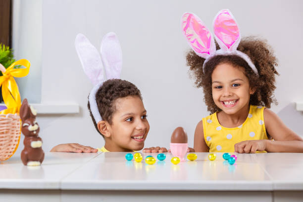 istock Black girl and a boy kids smile broadly play with Easter eggs 1369813069