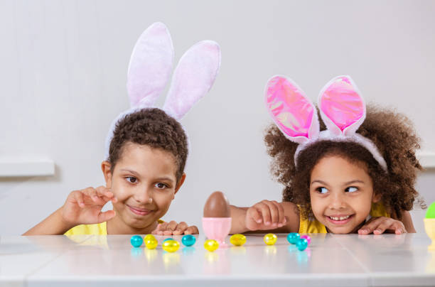 istock Black girl and a boy kids smile broadly play with Easter eggs 1369813077