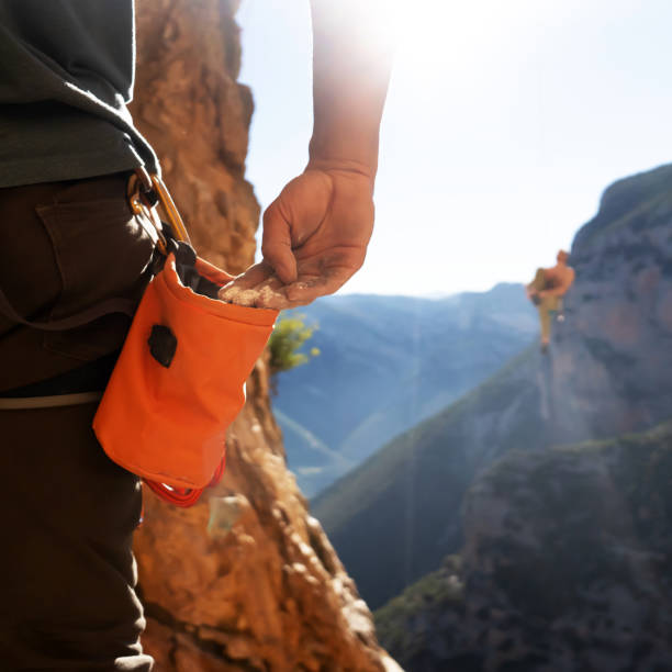 Male hand with magnesia powder close-up, against the background of beautiful mountains, the hand of climber who prepares for training outdoors, a man climbs in Twin Caves, Greece on a sunny day.