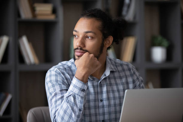 istock Thoughtful pensive Black freelance employee guy working at laptop 1369813844