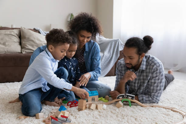 istock Happy young parents and two kids constructing building wooden blocks 1369813906
