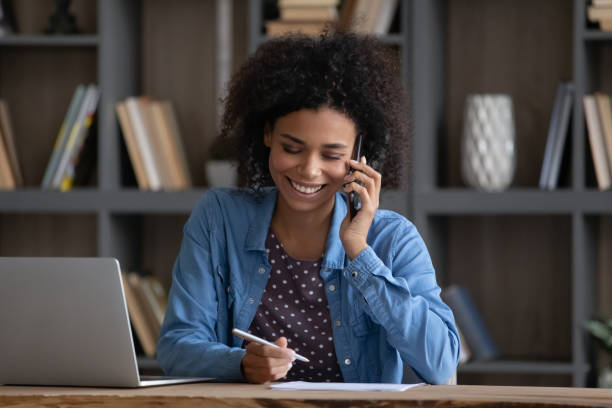 istock Happy Black freelance employee speaking to client on mobile phone 1369813985