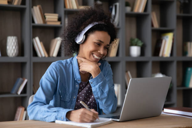 istock Cheerful laughing student girl in headphones watching learning virtual webinar 1369814255