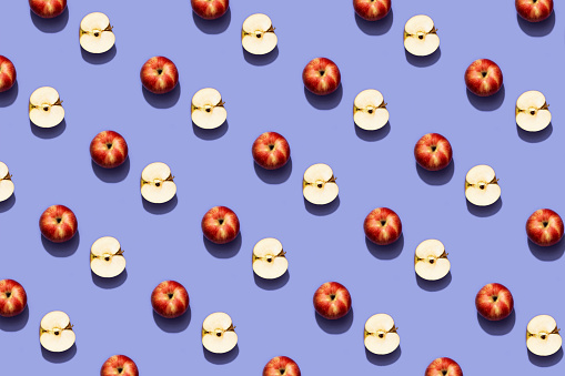 Fruit pattern red apple on trendy purple background. Violet and red colors background from fruity apple. Demonstrating the very peri, colors of 2022