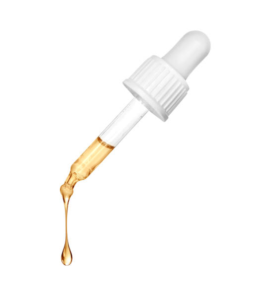 istock Stretched oily drop falls from a cosmetic pipette close-up on a white background 1369816807