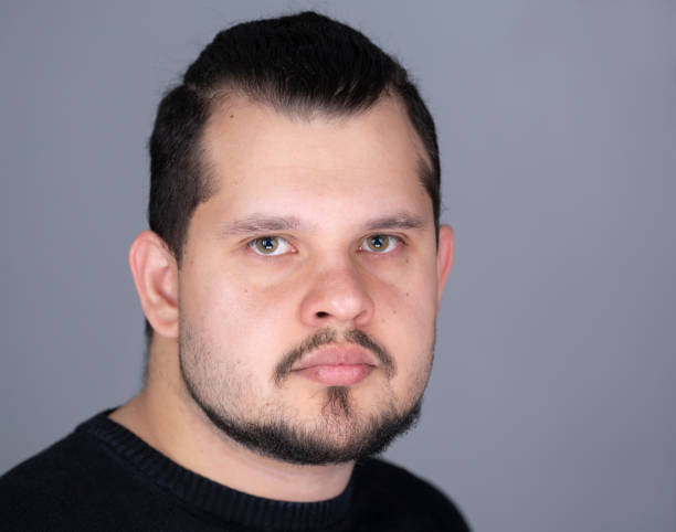 istock Young latin man studio left side headshot serious 1369819504