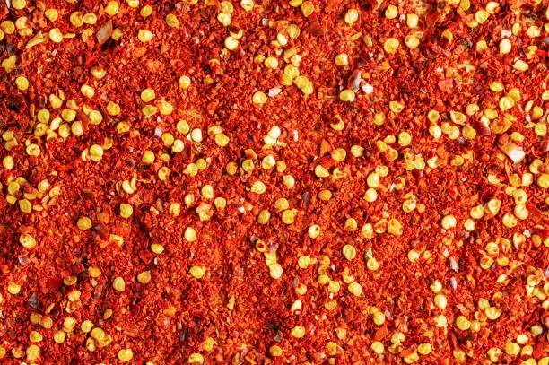 Photo of Dried red pepper powder. Background of crushed dry chili peppers.