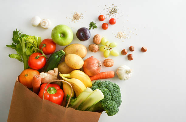 shopping bag riciclabile con frutta e verdura su tavola bianca - carrot vegetable isolated organic foto e immagini stock