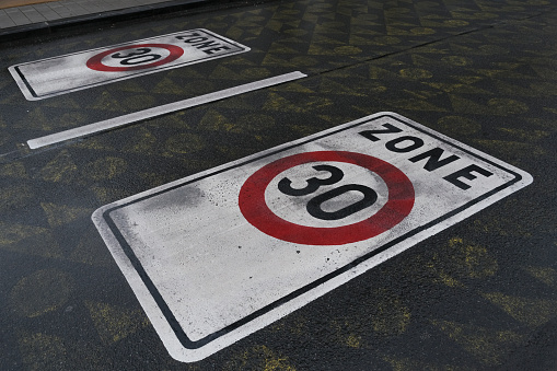 A traffic sign of 30km/h speed limit zone sign in front residential buildings in  Brussels, Belgium on February 10, 2022.