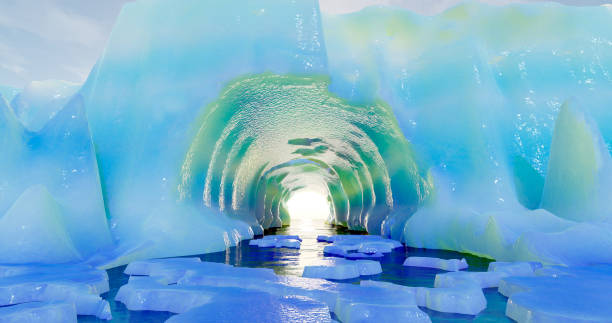 istock 3d rendering. An arctic glacier with an ocean tunnel and small ice floes floating around against a blue sky with clouds. 1369826734