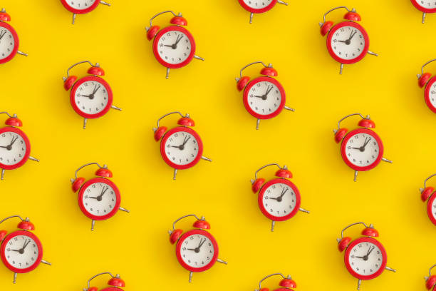 istock Pattern composition of  black antique alarm clock on yellow background. Flat lay composition. Top view. 1369827985