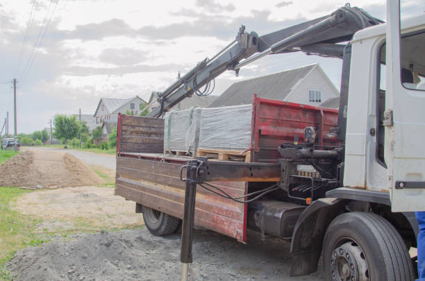 A semi truck hauls a large earthmover down the road.
