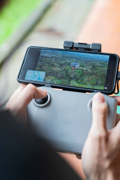 istock Man drives drone from above watching it from the screen 1369828742