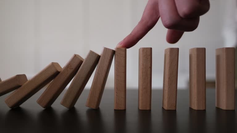 Geschäftsmann stoppen Domino-Effekt. Risikomanagement und Versicherungskonzept