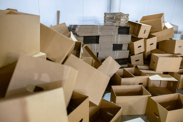 istock Assembled and disassembled folding cardboard boxes of perforated sheets of corrugated cardboard. Packaging of finished products in industrial production. 1369835086