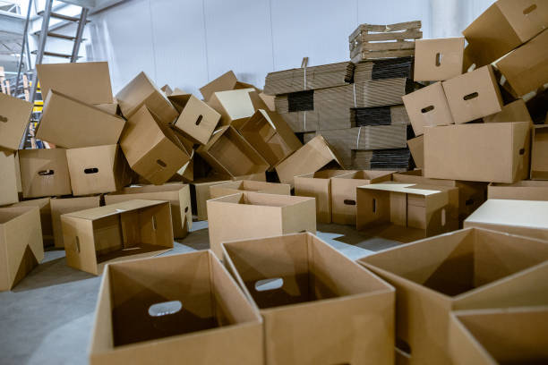 istock Assembled and disassembled folding cardboard boxes of perforated sheets of corrugated cardboard. Packaging of finished products in industrial production. 1369835087