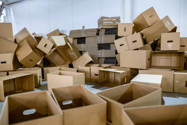 istock Assembled and disassembled folding cardboard boxes of perforated sheets of corrugated cardboard. Packaging of finished products in industrial production. 1369835089