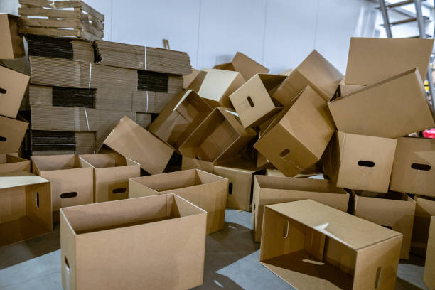 istock Assembled and disassembled folding cardboard boxes of perforated sheets of corrugated cardboard. Packaging of finished products in industrial production. 1369835090