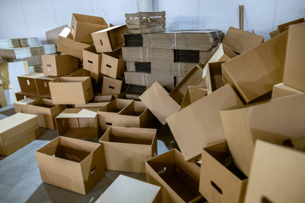 istock Assembled and disassembled folding cardboard boxes of perforated sheets of corrugated cardboard. Packaging of finished products in industrial production. 1369835097